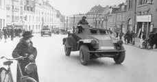 Német páncélautók haladnak át egy dán városon