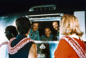 Neil Armstrong, Buzz Aldrin és Michael Collins köszöntik feleségeiket a U.S.S. Hornet repülőgép-hordozó fedélzetén lévő mobil karantén egységből. A hadihajó Hawaiitól körülbelül 800 tengeri mérföldre (1500 kilométerre) délnyugatra „gyűjtötte be” a visszatért űrhajósokat az óceánból, és elővigyázatosságból néhány napig karanténban tartották őket. (kép forrása: Vintage Everyday)