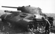 Német katona vizsgál egy még füstölgő kilőtt T-34-est