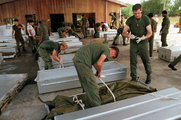 Amerikai katonák koporsókba helyezik a halottakat a guyanai Georgetown nemzetközi repülőterén