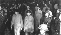Elfogott amerikai pilóták felvonultatása a hangosbemondókkal feltüzelt, dühödt hanoi tömegek előtt 1966 júliusában. A második sorban balról az első férfi Bob Shumaker. (kép forrása: nationalmuseum.af.mil)