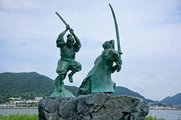 Mijamoto Muszasi és Szaszaki Kódzsiró párbajának emléket állító szobrok Ganrjú-dzsima szigetén (az ugró alak Muszasié, a térdelő Szaszakié) (kép forrása: learning-history.com)