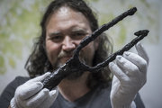 Wilhelm Gábor ásatásvezető régész Tiszaug közelében talált szigonyt tart a kezében (kép forrása: MTI / Ujvári Sándor)