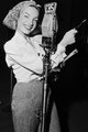 Carmen Miranda, 1944 – a brazil énekesnő a CBS rádió karácsonyi műsora számára való felvétel készítése közben haját mintás fejkendőbe fogta, ehhez hosszú ujjú fehér inget és magas derekú, gingham anyagú nadrágot viselt.