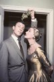 Anne Jeffreys, 1954 – a színésznő sorozat- és valóságbeli párjával, Robert Sterlinggel csókot készül váltani a fagyöngy alatt, igencsak ünnepélyes aranyszínű hajónyakú ruhában.