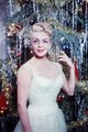 Lana Turner, 1955 – a színésznő a téli hóhoz illő fehér tüll estélyiben áll a karácsonyfa előtt, melynek díszeit túlragyogják gyémánt fülbevalói.