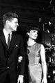 John F. Kennedy elnök és felesége, Jackie, 1962 – a first lady a Fehér Ház karásconyfájában gyönyörködik 1962-ben. A divatikonná vált asszonyon egyik legjellegzetesebb viselete, egy ujjatlan szaténruha látható.