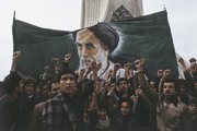 Tüntetők a magasba emelnek egy Khomeini ajatollahot ábrázoló transzparenst a teheráni Azadi (Szabadság) torony előtt a forradalom idején, 1978.